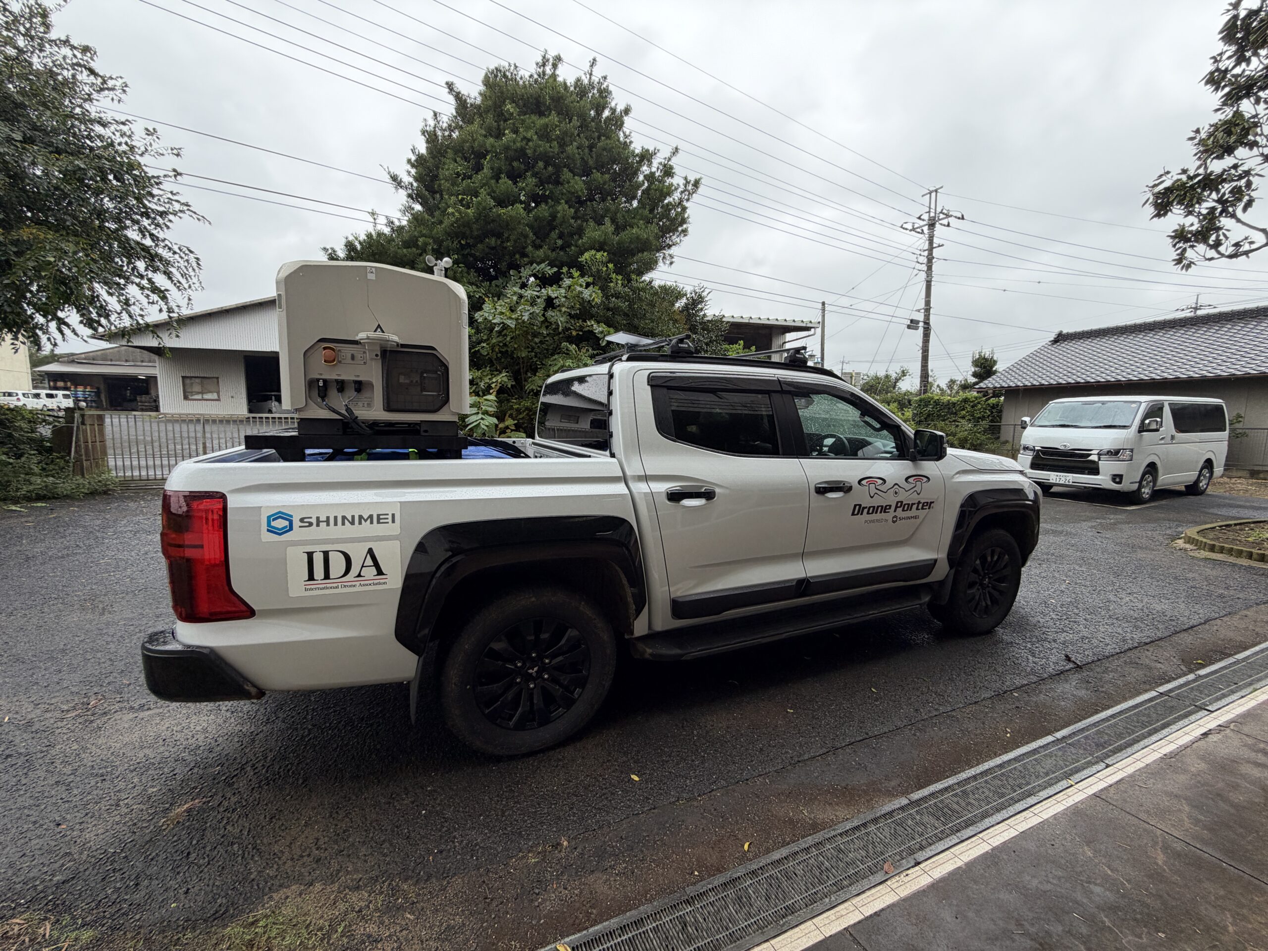 荷台にドローン運用機材を搭載した白い高機動型ドローンポーターの側面